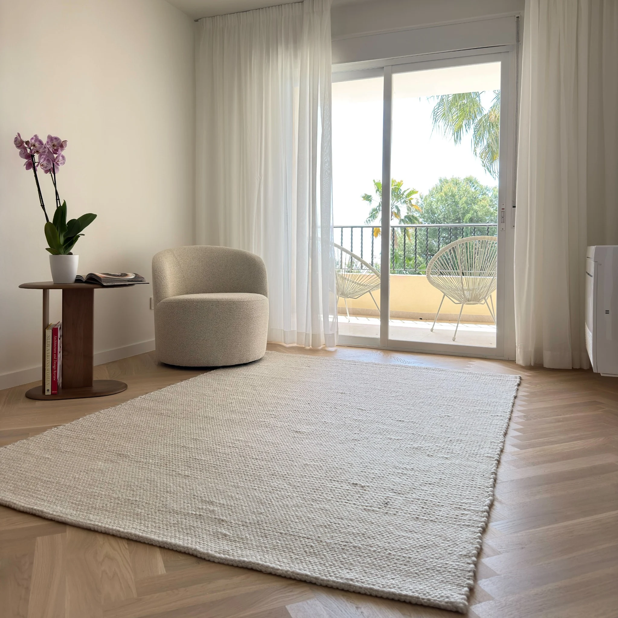 Light-filled additional room with chair and access to terrace